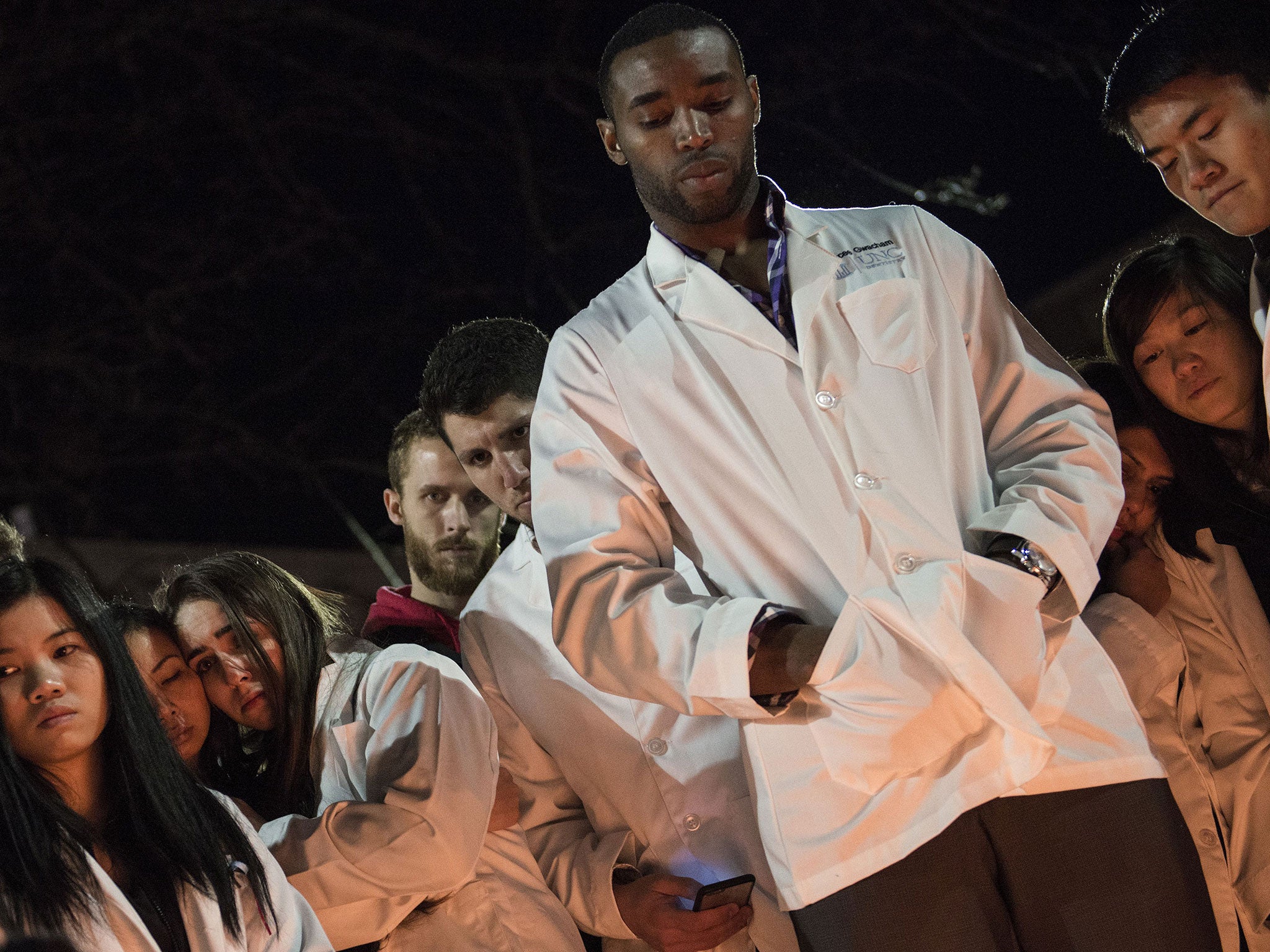 Dentistry students and others huddle together during a vigil at the University of North Carolina following the murders of Deah Shaddy Barakat, his wife Yusor Mohammed and her sister Razan Mohammed Abu-Salha