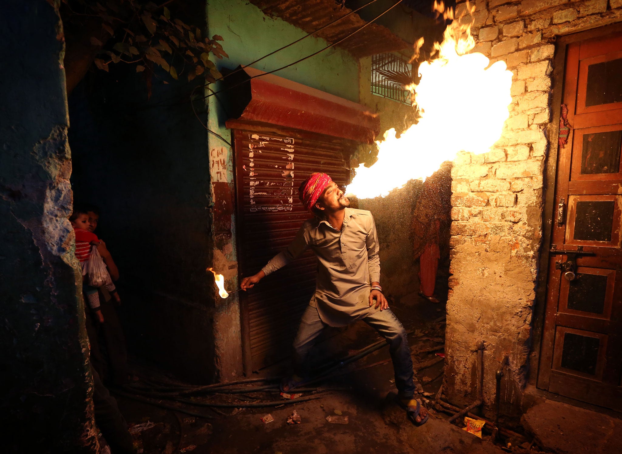 Fire breather Amit Kumar Bhatt practising his craft at his home in the Kathputli colony