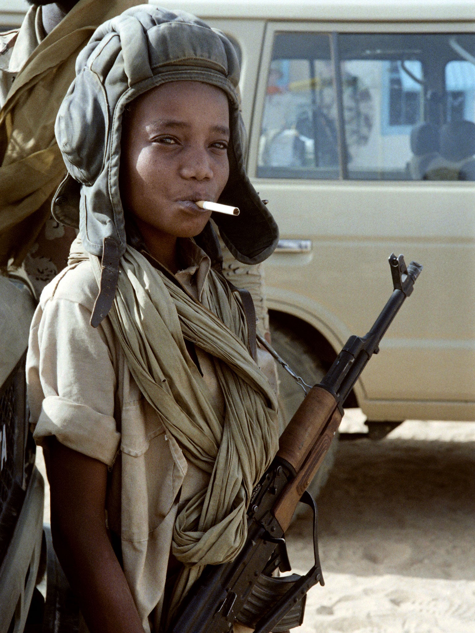 A Chadian child soldier poses with a Libyan helmet, cigarette and Kalashnikov in 1987 after the defeat of Libyan army