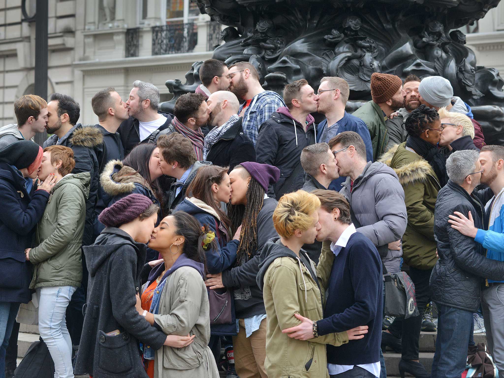 Crowds gather beneath the Eros Fountain in London