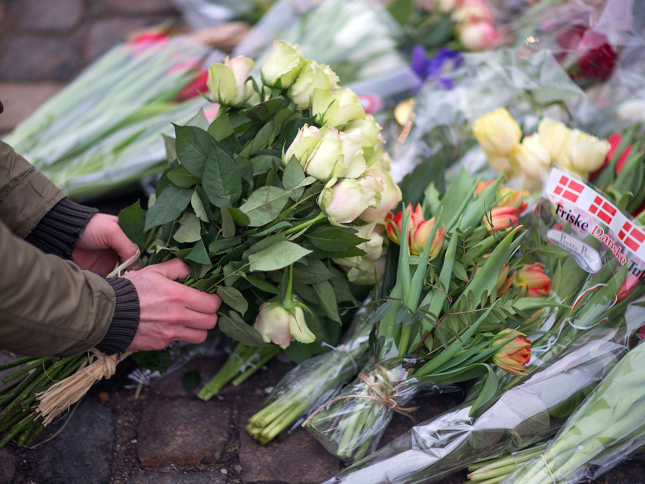 A man places flowers close to the scene of the cafe shooting