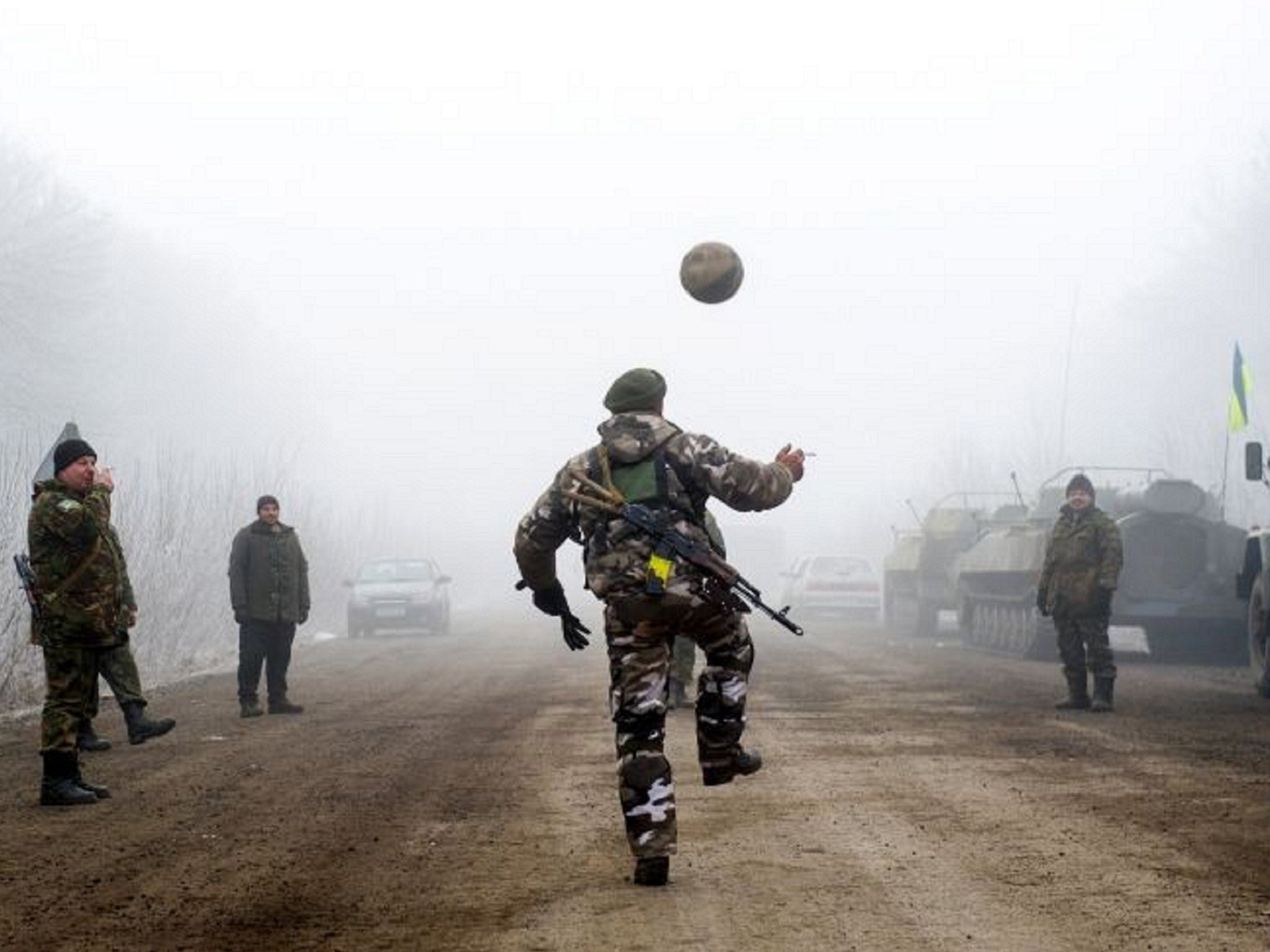 Ukrainian servicemen play football on a road at Svitlodarsk during the ceasefire