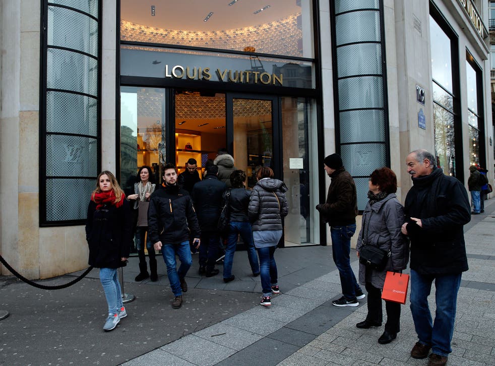Shoppers enter a store on the Champs Elysees avenue, in Paris. France's lower house of parliament has approved a set of measures allowing more stores to open on Sundays and evenings, especially in touristy areas