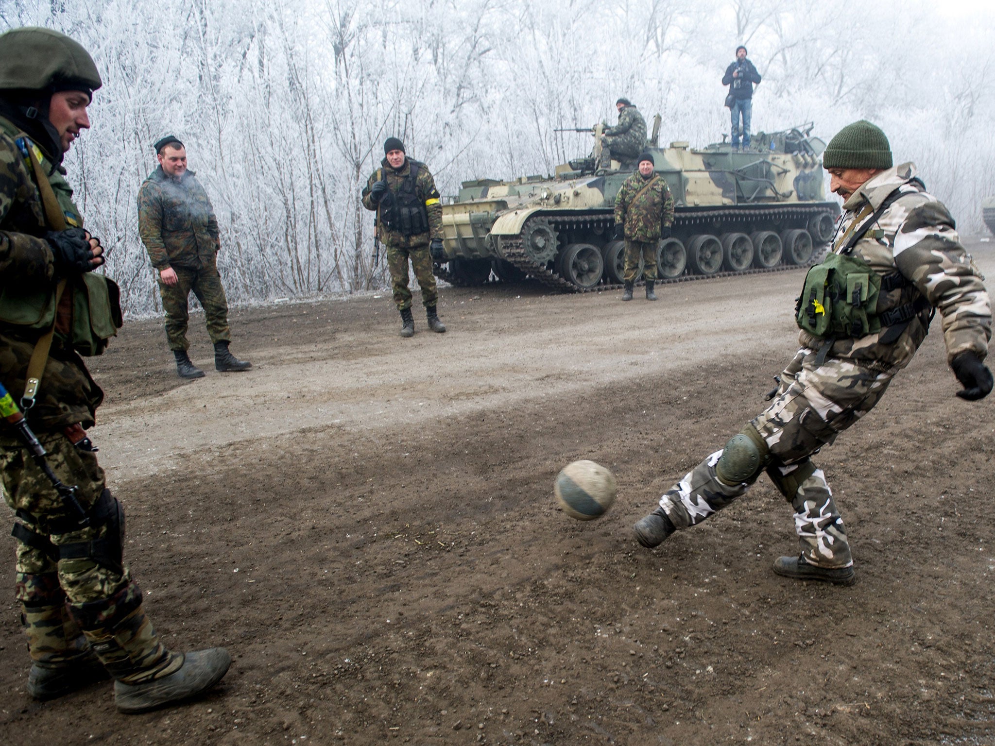 Ukrainian soldiers play football on the road leading to Debaltseve