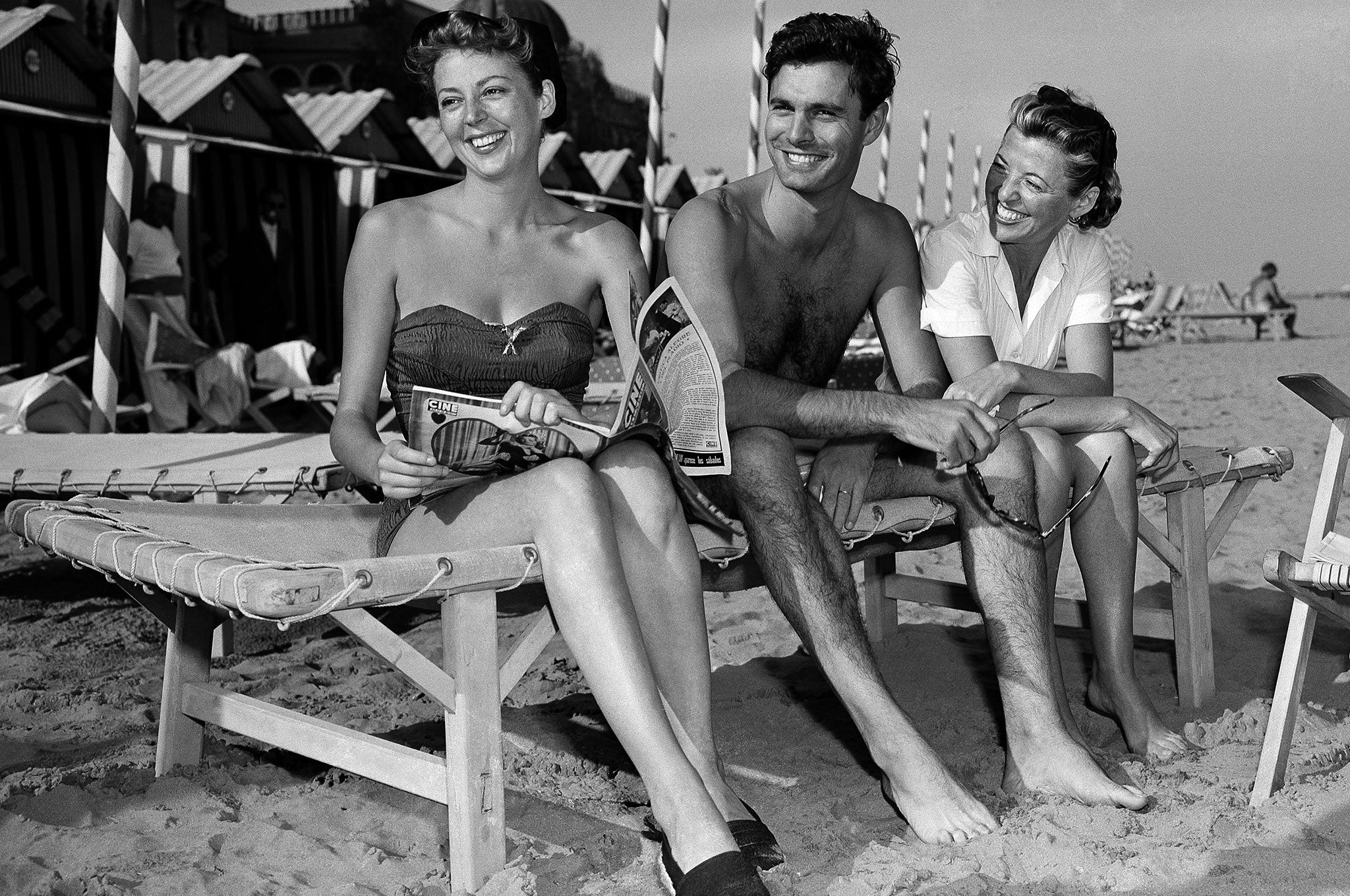 Louis Jourdan with actress Anne Vernon, left, and his wife Berthe Fredrique on the beach at Lido isle in Venice, Italy