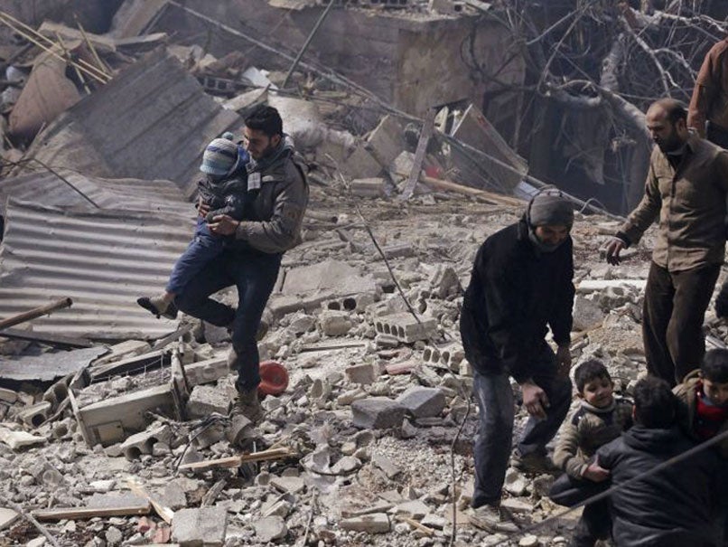 Men carry children from a site hit by what activists said were air strikes by forces loyal to Syria's President in the Douma neighborhood of Damascus, 9 February 2015