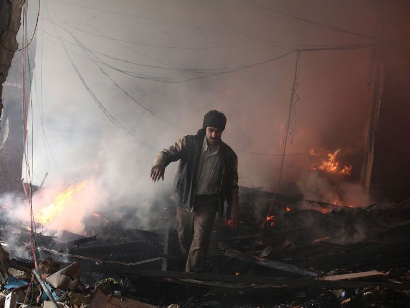 A Syrian man walks amid debris inside a heavily damaged building following reported air strikes by regime forces in the rebel-held area of Douma, on February 9, 2015.