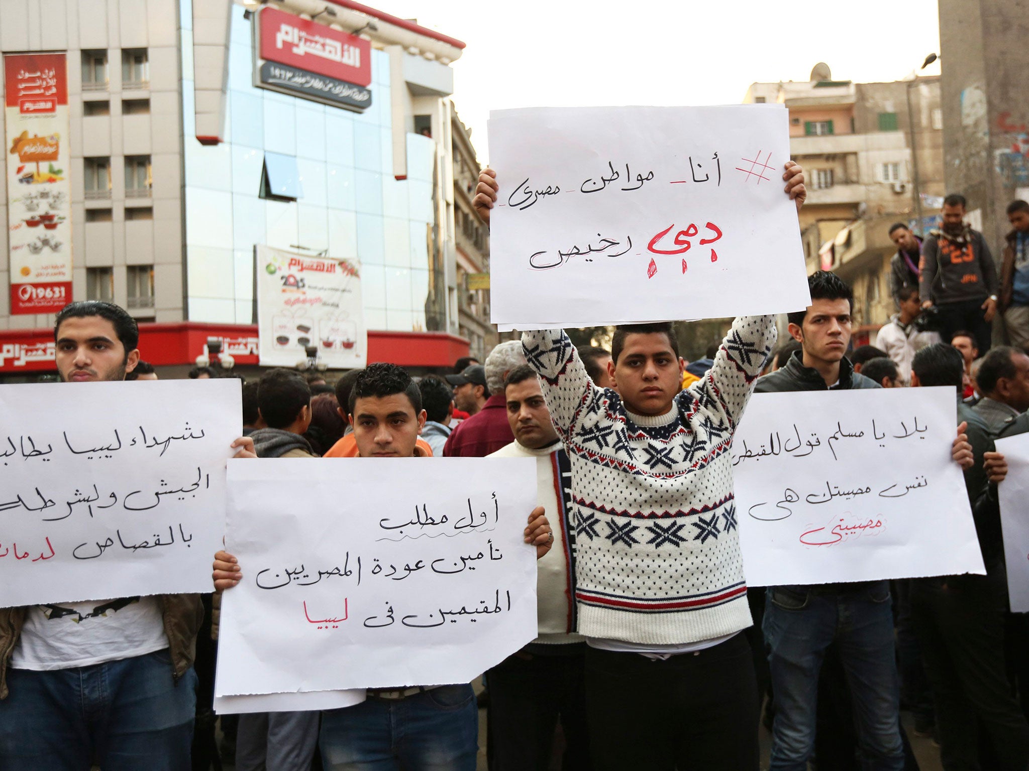 Protesters hold placards during a demonstration against the killing of Egyptian Coptic Christians (Reuters)