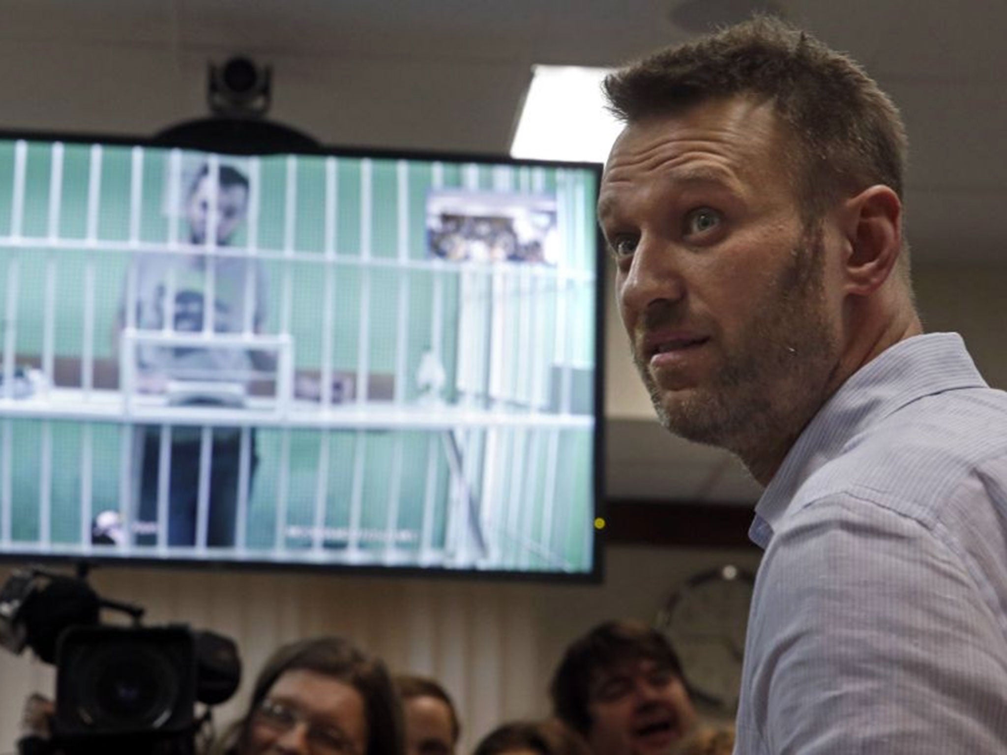 Alexei Navalny at Moscow City Court today, as his jailed brother Oleg is screened from prison (Image: EPA)