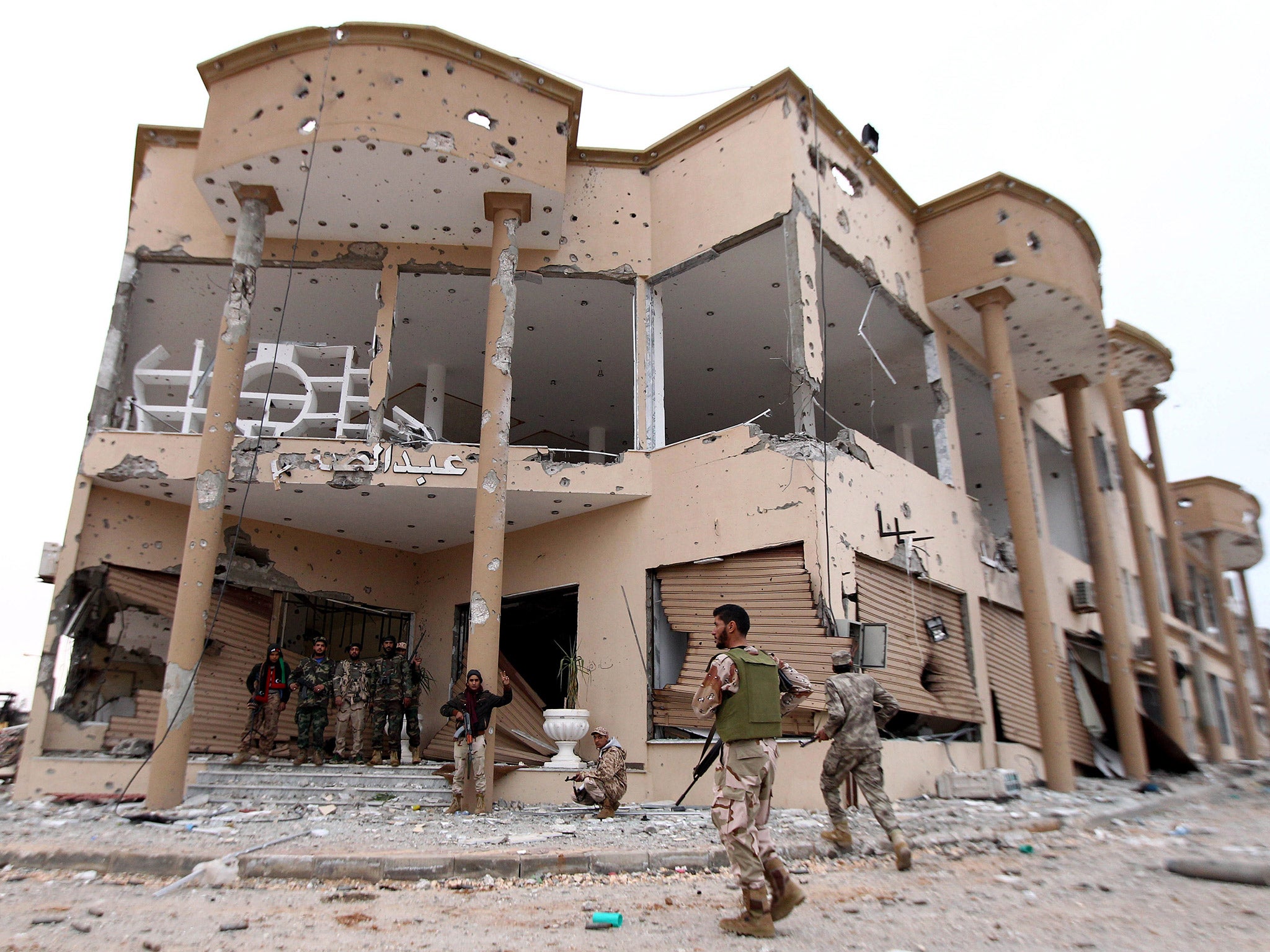 Libyan National Army fighters stand at the entrance of a destroyed building after clashes with Isis in Benghazi, last December