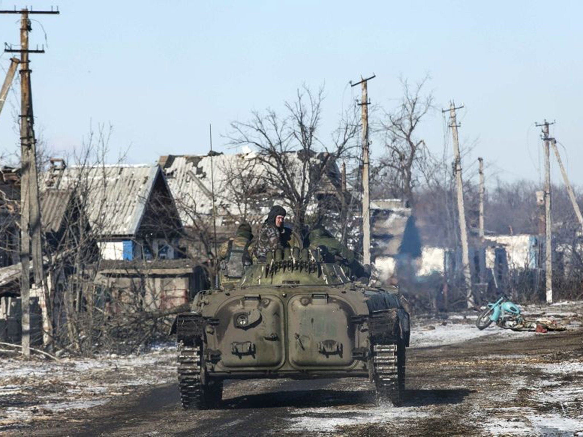 Fighters with separatist self-proclaimed Donetsk People's Republic army ride through the ruined village of Nikishine, south east of Debaltseve, on 17 February