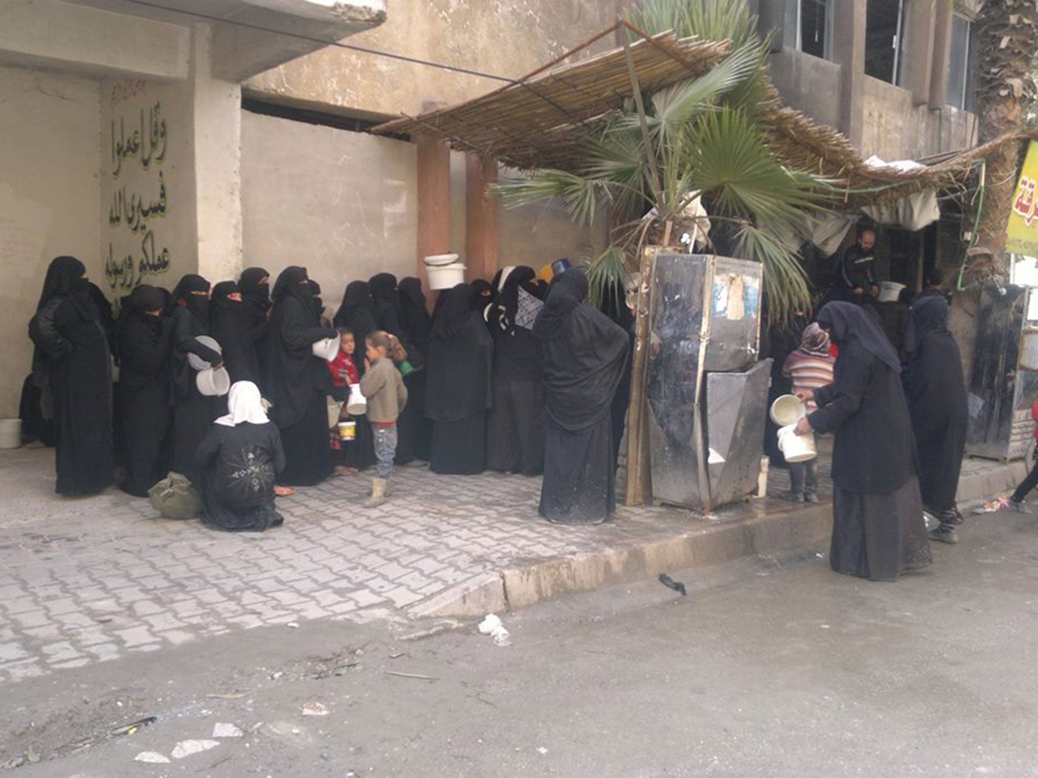 Women living under Isis gather in Raqqa to collect food relief