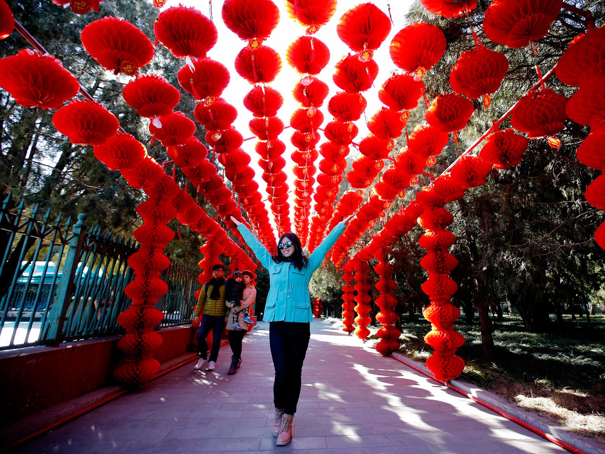 A woman stands under paper lanterns, celebrating the Chinese New Year at Ditan Park in Beijing (Reuters)