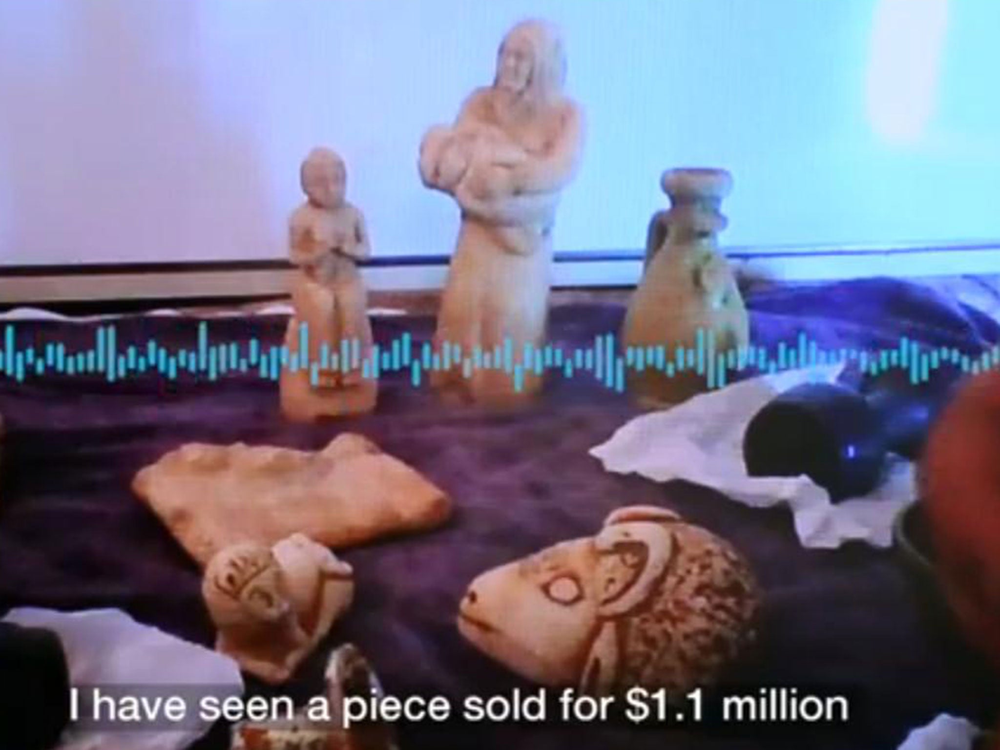 A middle man shows artefacts being offered by a Syrian smuggler (BBC)