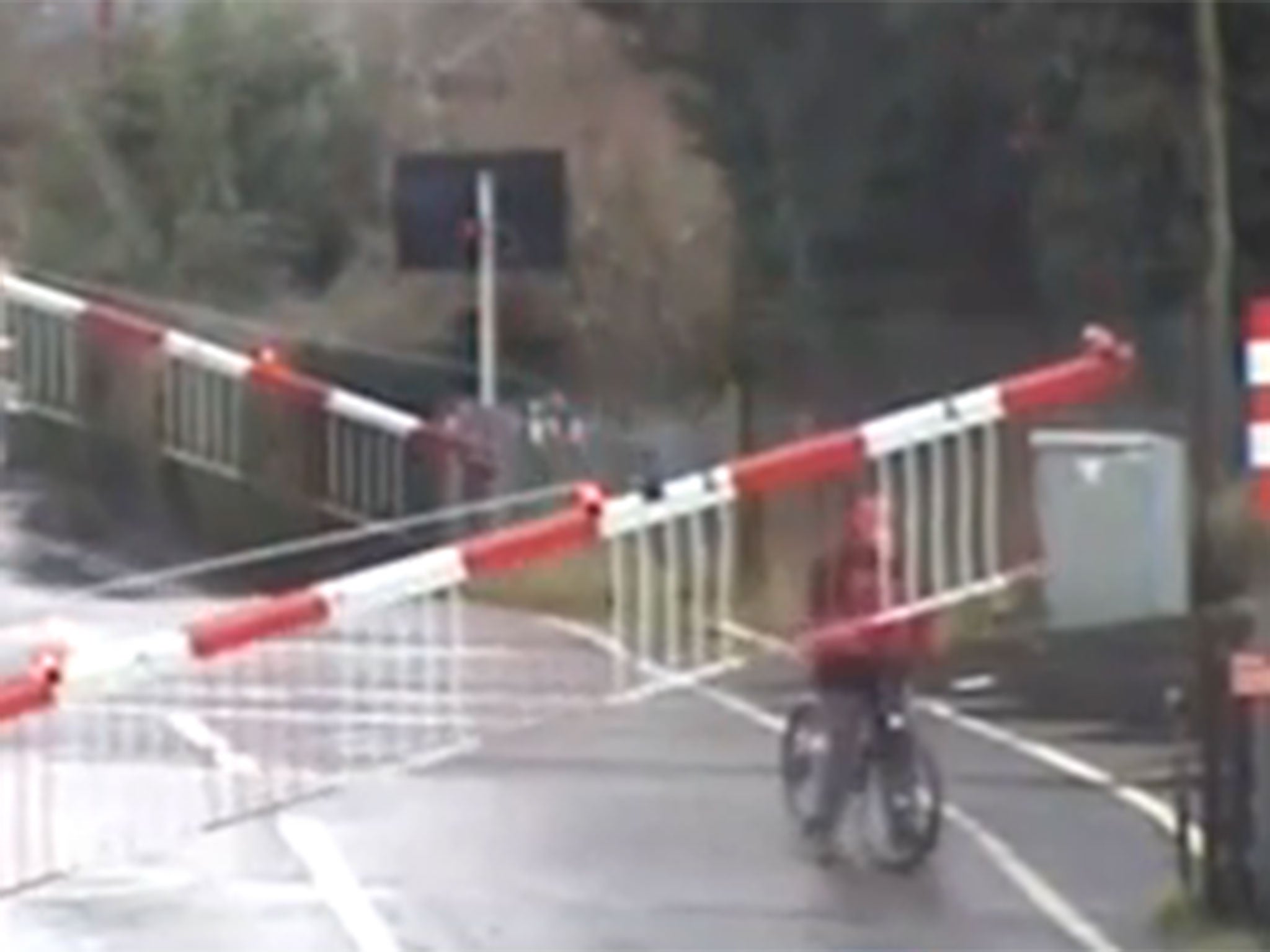 The cyclist became trapped after the level crossing barriers came down