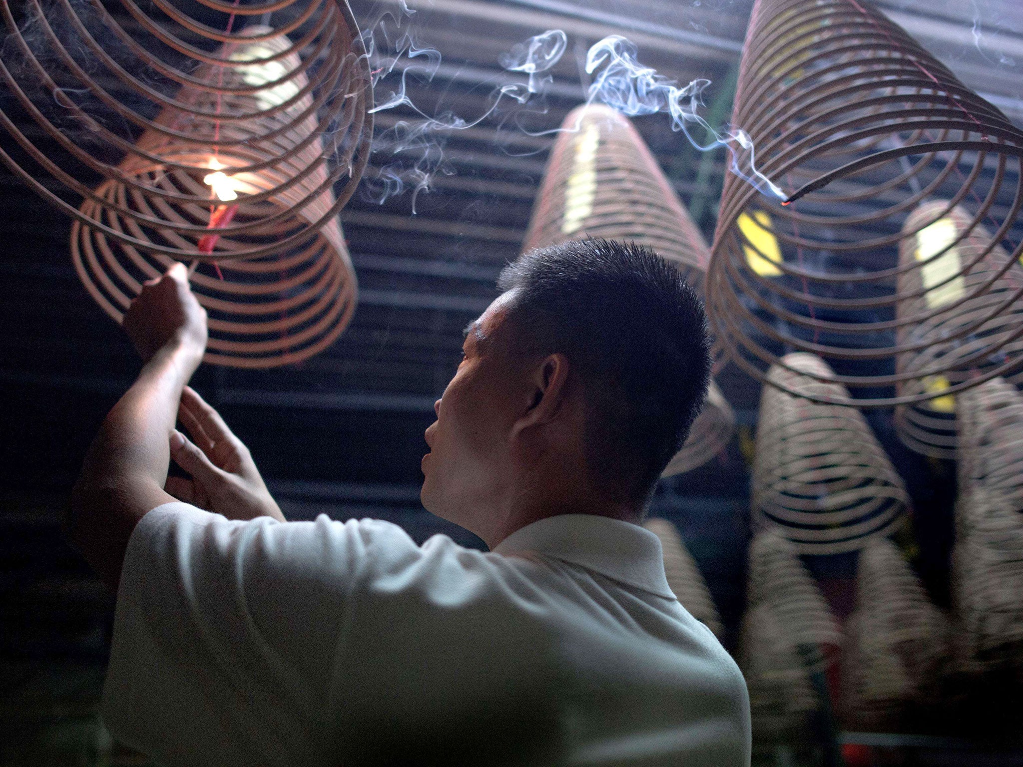 A Malaysian ethnic Chinese man burns spiral joss sticks to welcome the Chinese New Year at a temple in Ampang, in the suburbs of Kuala Lumpur