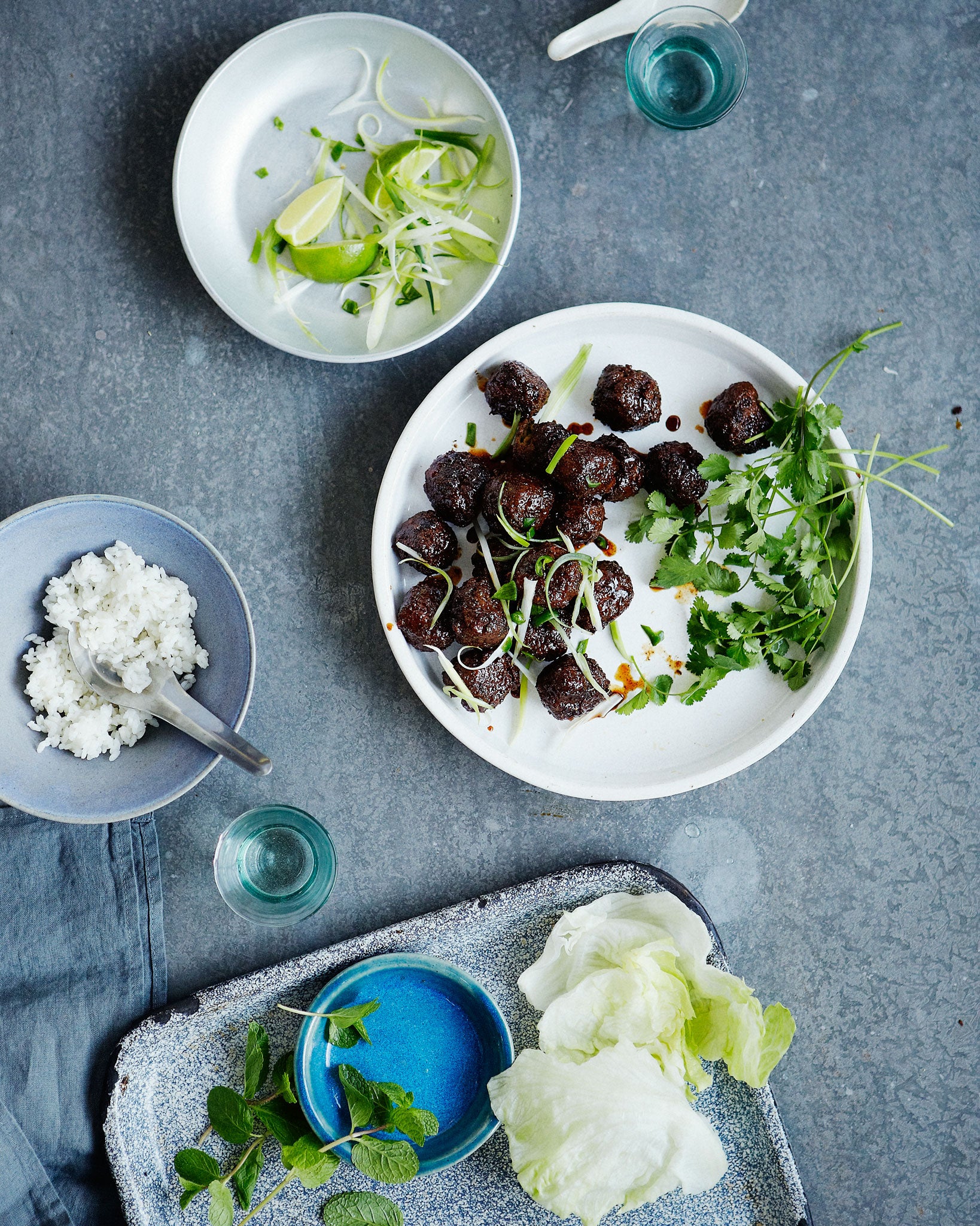 Pork meatballs with sticky rice and lime wedges