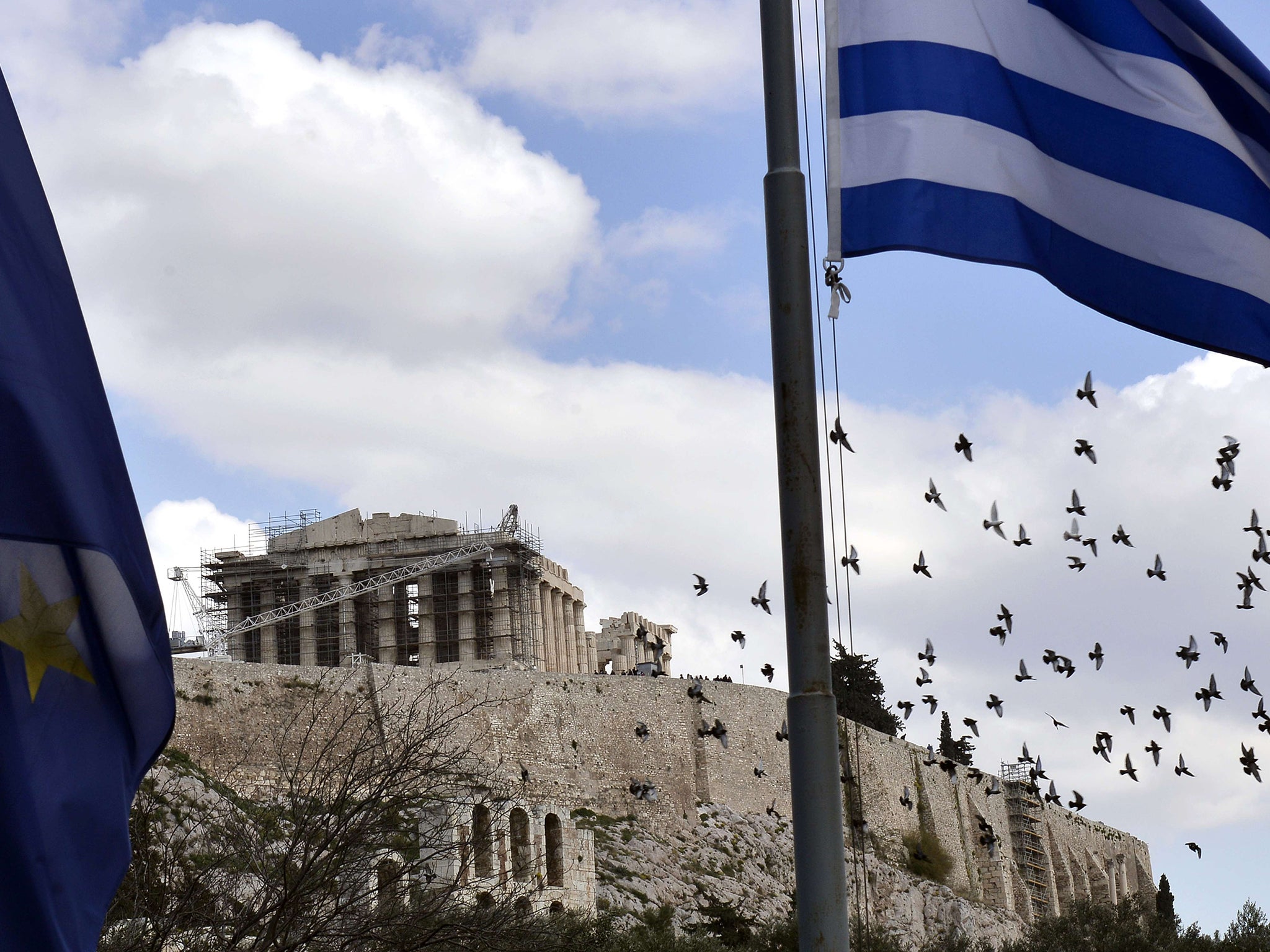 EU and Greek flags fly outside the Acropolis in Athens yesterday, as Greece asked its EU creditors for a six-month bailout extension