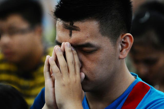 A Catholic man prays during the Ash Wednesday ceremony at Roh Kudus Church on March 5, 2014 in Surabaya, Indonesia. 