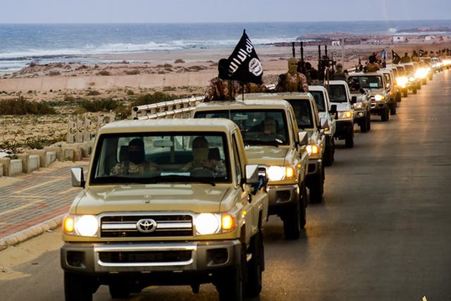 Isis militants process down a street in the coastal city of Sirte in Libya