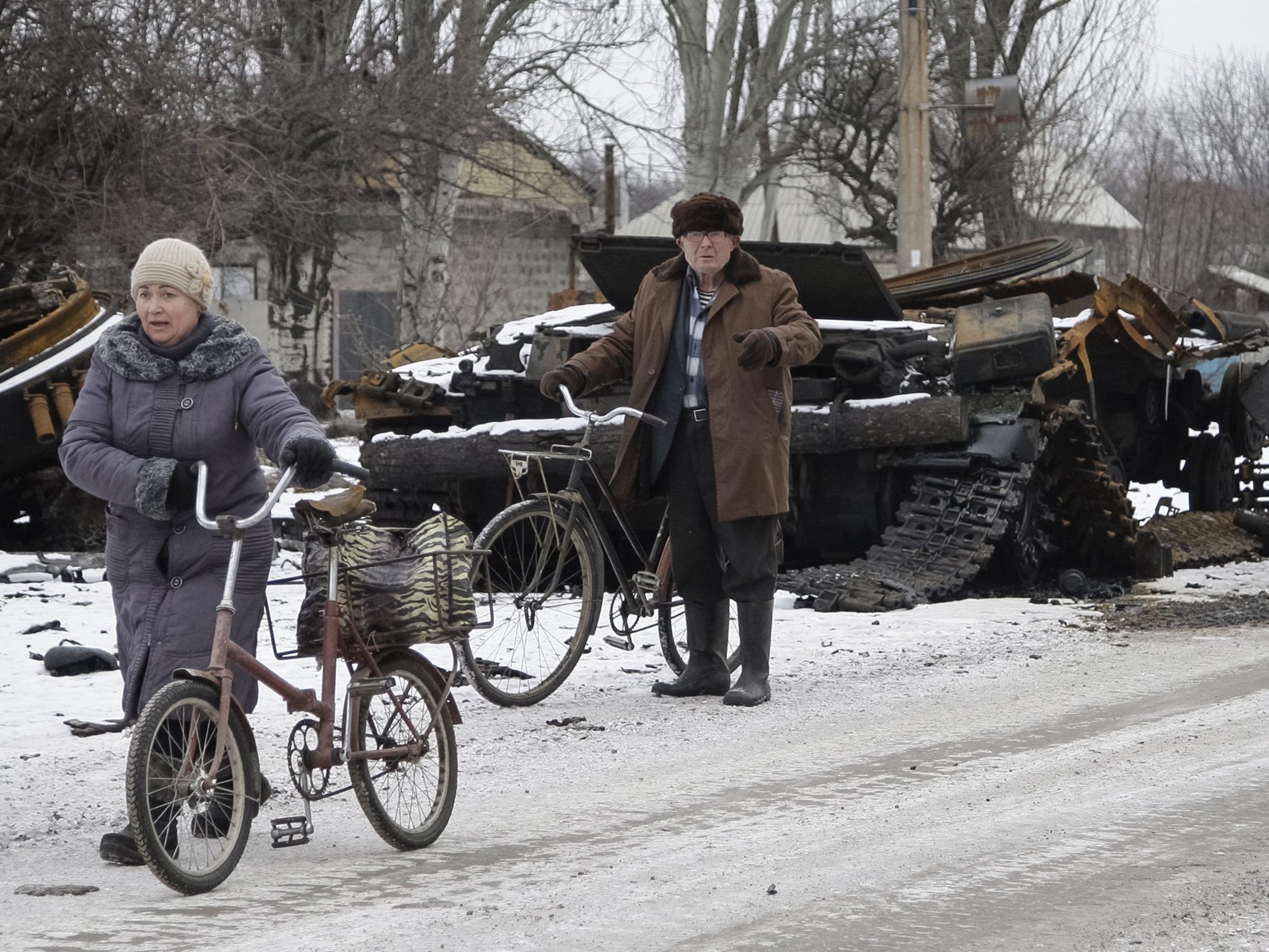 Residents pass a burnt military vehicle yesterday in Uglegorsk, not far from
Debaltseve