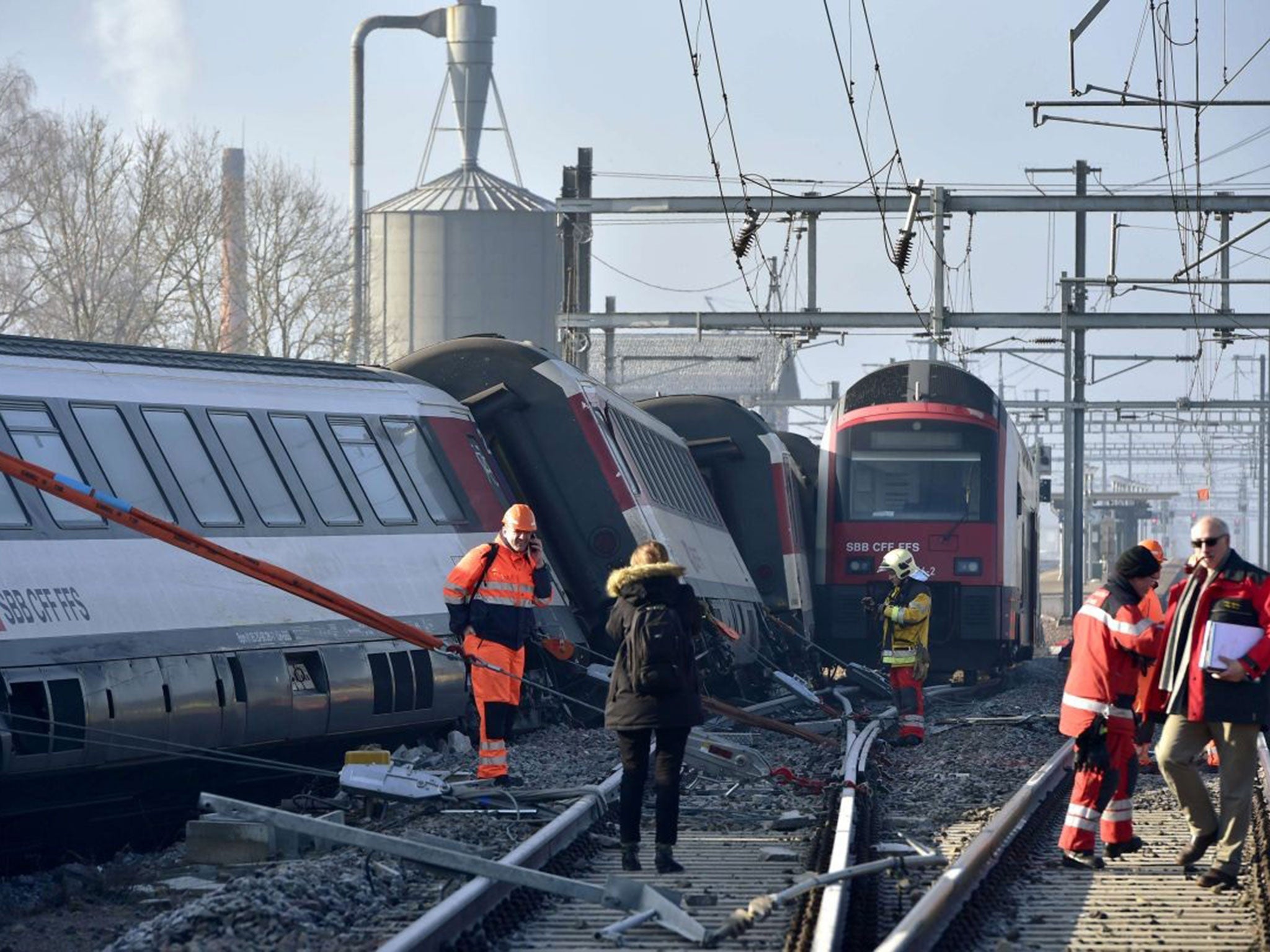 Rescue workers inspect the site of a train crash at the train station of Rafz, northern Switzerland, on February 20, 2015.
