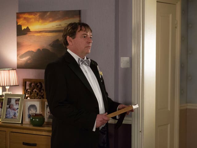 Ian Beale (played by Adam Woodyatt) holds on to the picture of his family