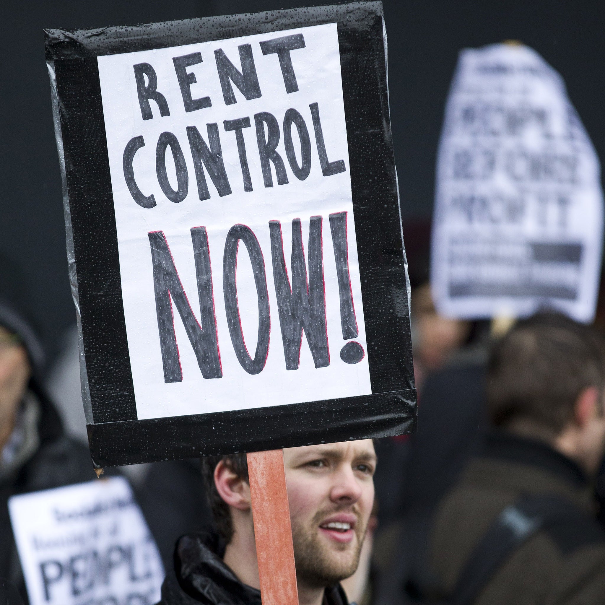 A protester holds a placard that reads 'Rent Control Now!' during a demonstration dubbed 'The March for Homes'