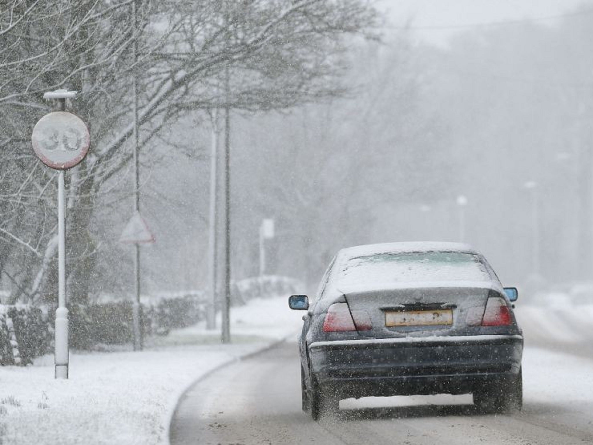 A car makes its way through sleet and snow in Buxton, Derbyshire