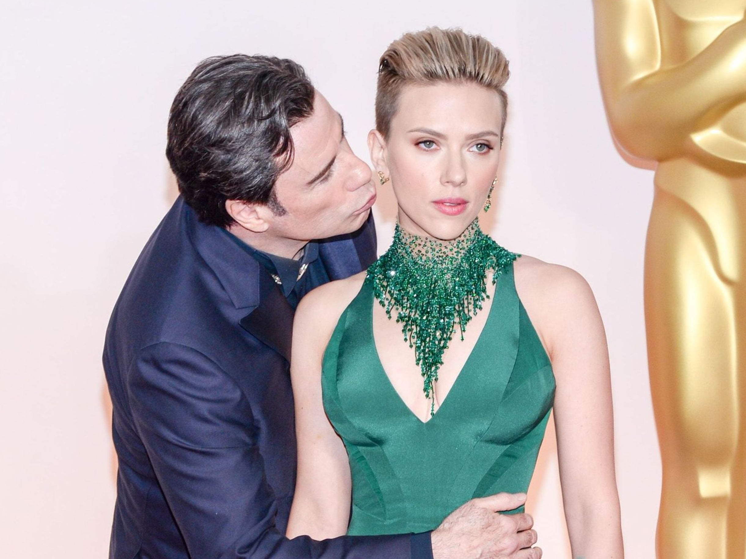 Johansson didn't look delighted by Travolta's handsy display