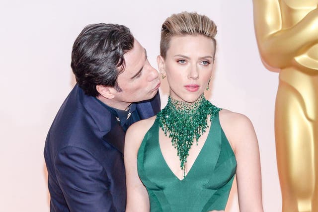 Johansson didn't look delighted by Travolta's handsy display