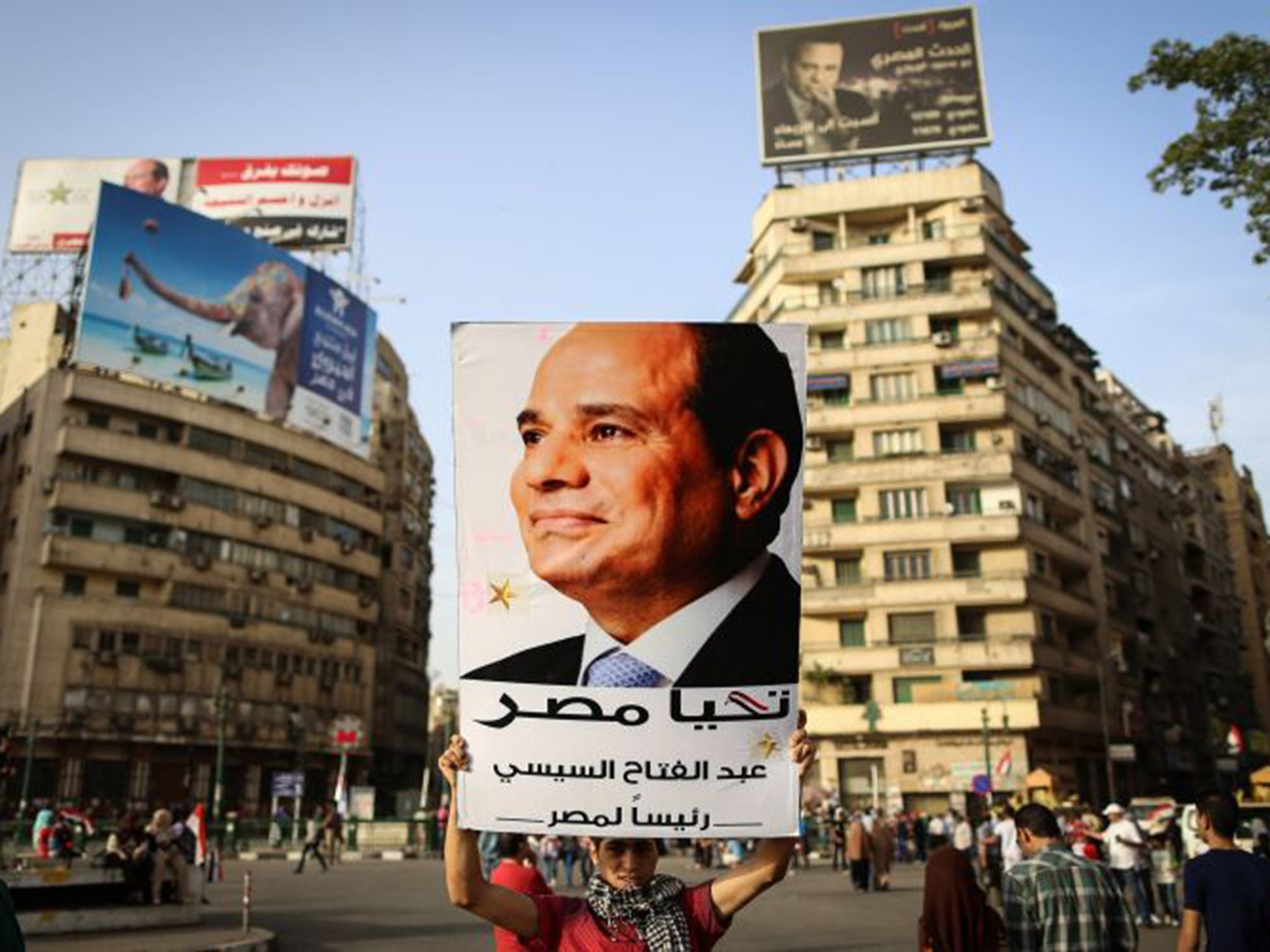 A man holds a portrait of Abdel Fattah al-Sisi as he celebrates in Cairo’s Tahrir Square in June