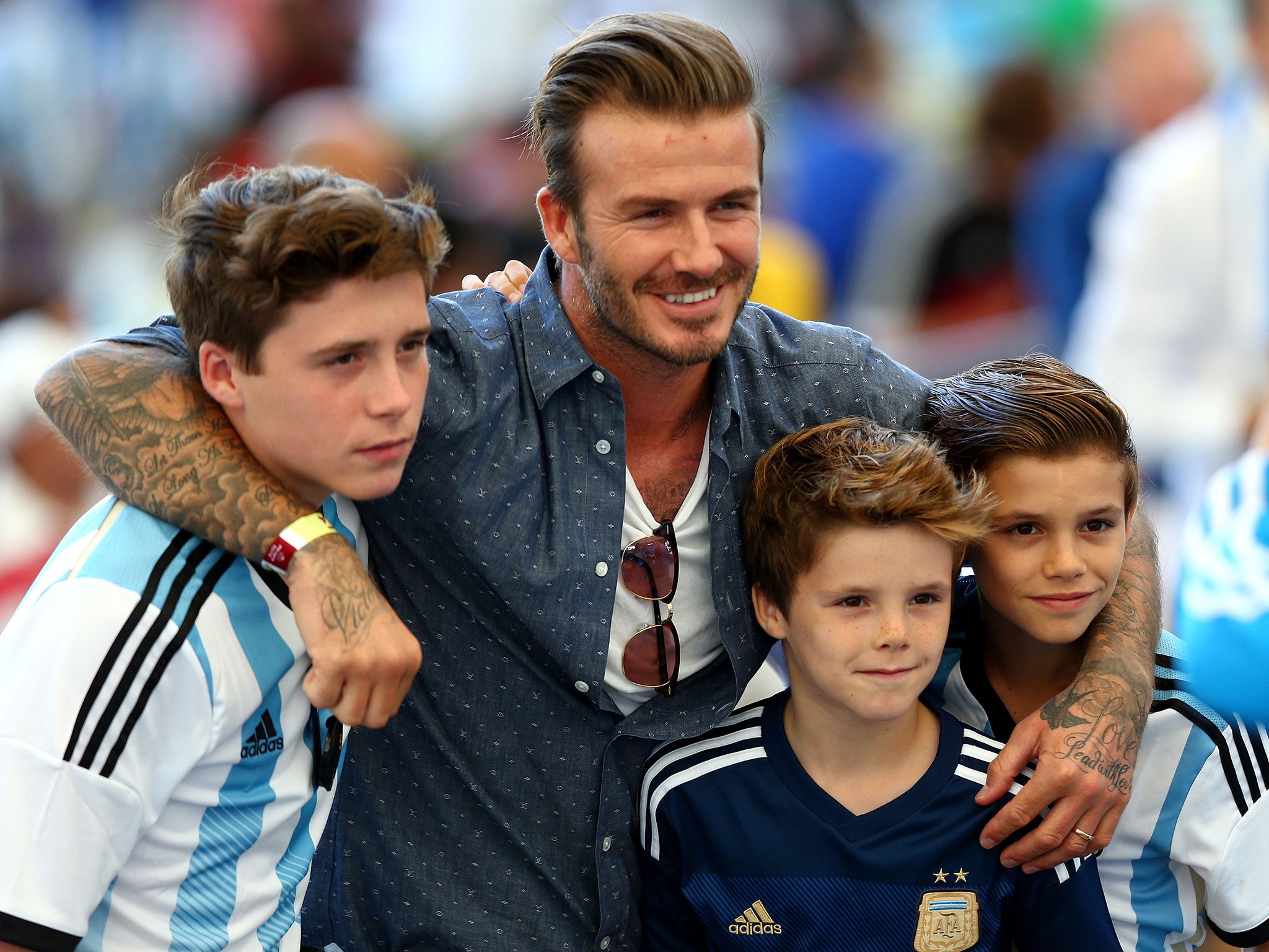 David Beckham poses with his three sons at last summer's World Cup