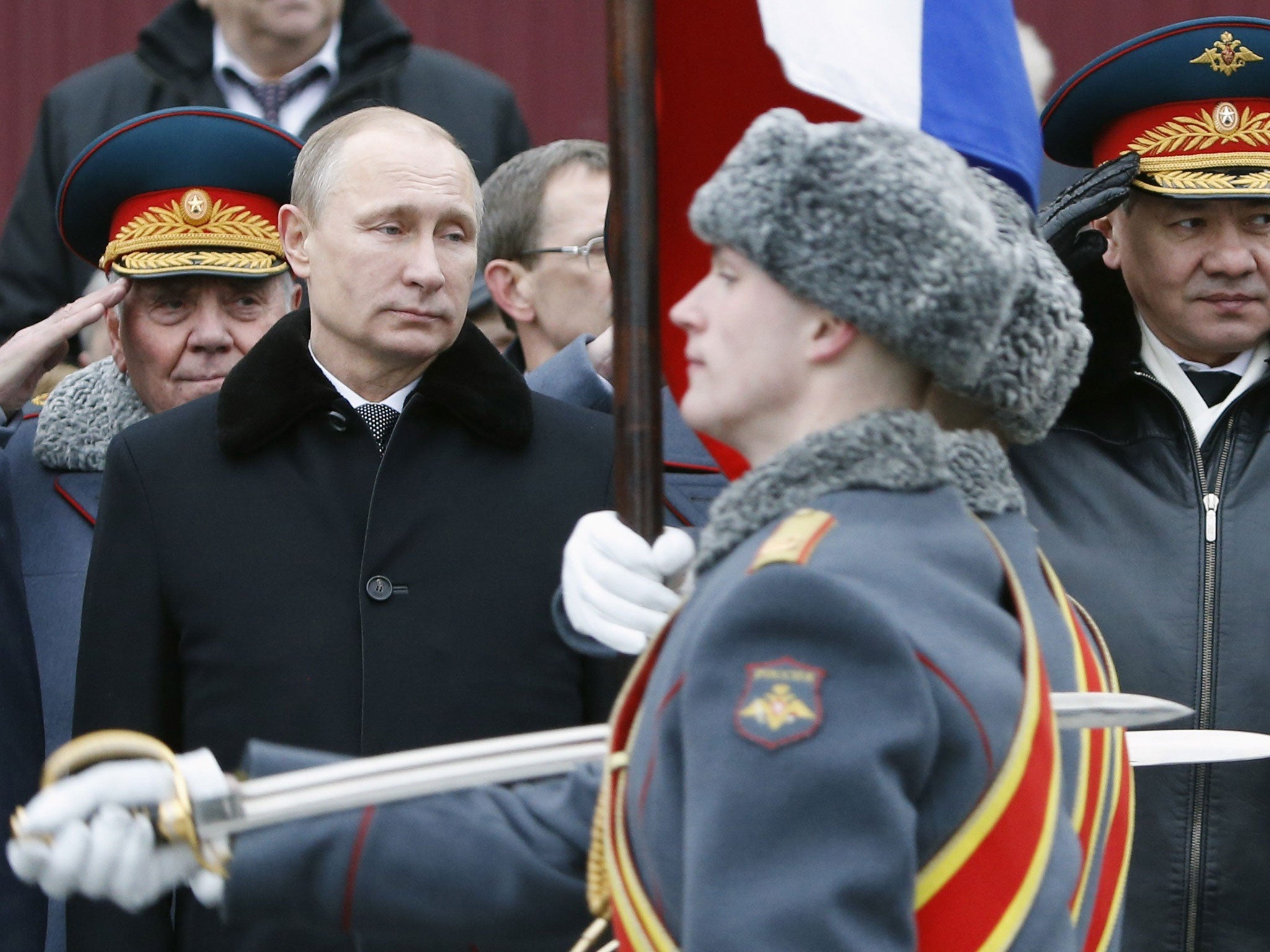Russian President Vladimir Putin watches honor guards pass by as they attend a wreath laying ceremony to mark the Defender of the Fatherland Day at the Tomb of the Unknown Soldier in central Moscow, 23 Feb