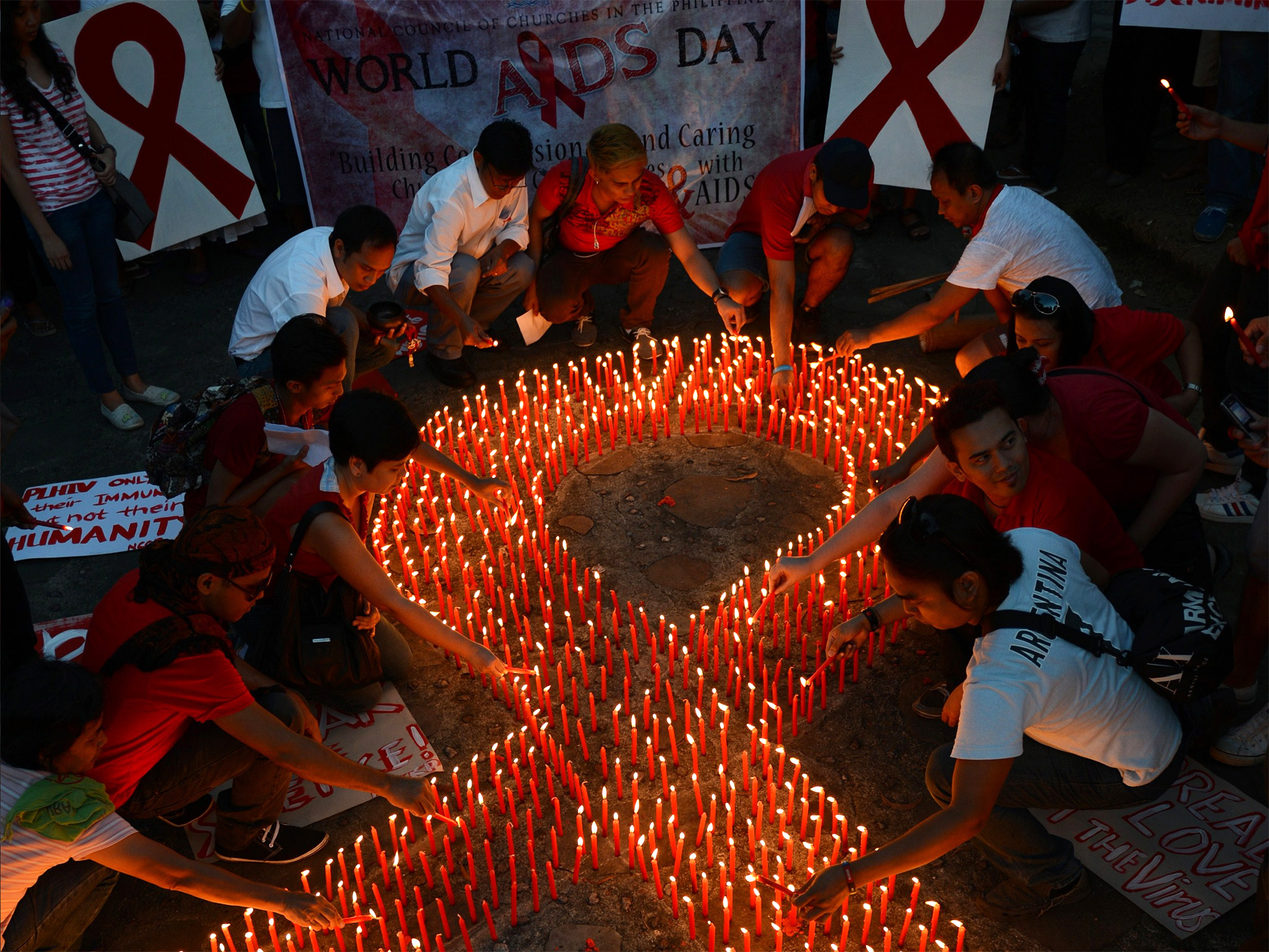 Activists light candles on World Aids Day in Manila. HIV infection rates have remained high in Britain for a decade