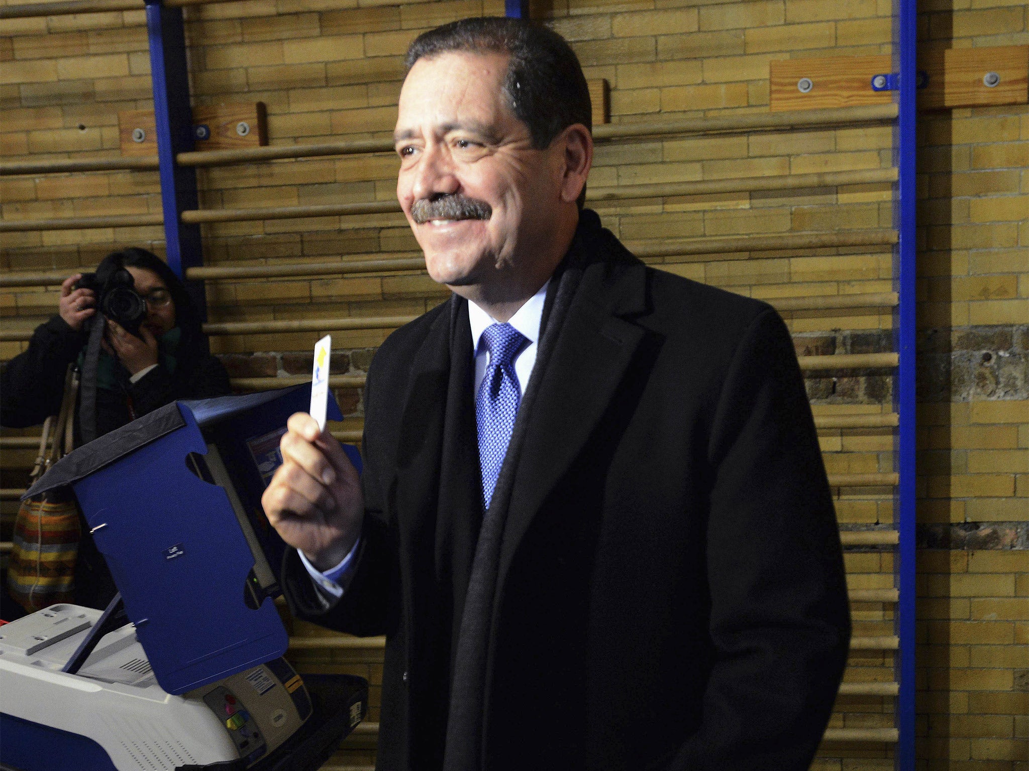 Chicago mayoral candidate, Jesus Garcia, smiles as he holds his electronic card after voting on Tuesday