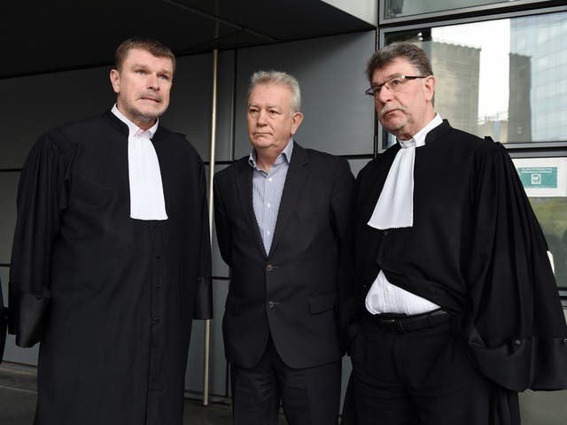 Aquitted defendant Alain Deverini (centre) speaks with his lawyers outside court