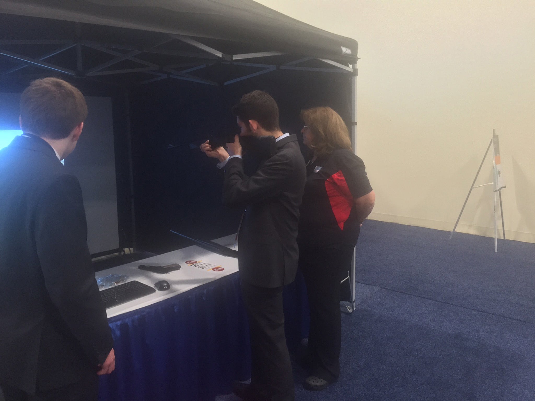 A man shoulders a gun to take target practice in one exhibition at CPAC. It was not a real gun, of course.