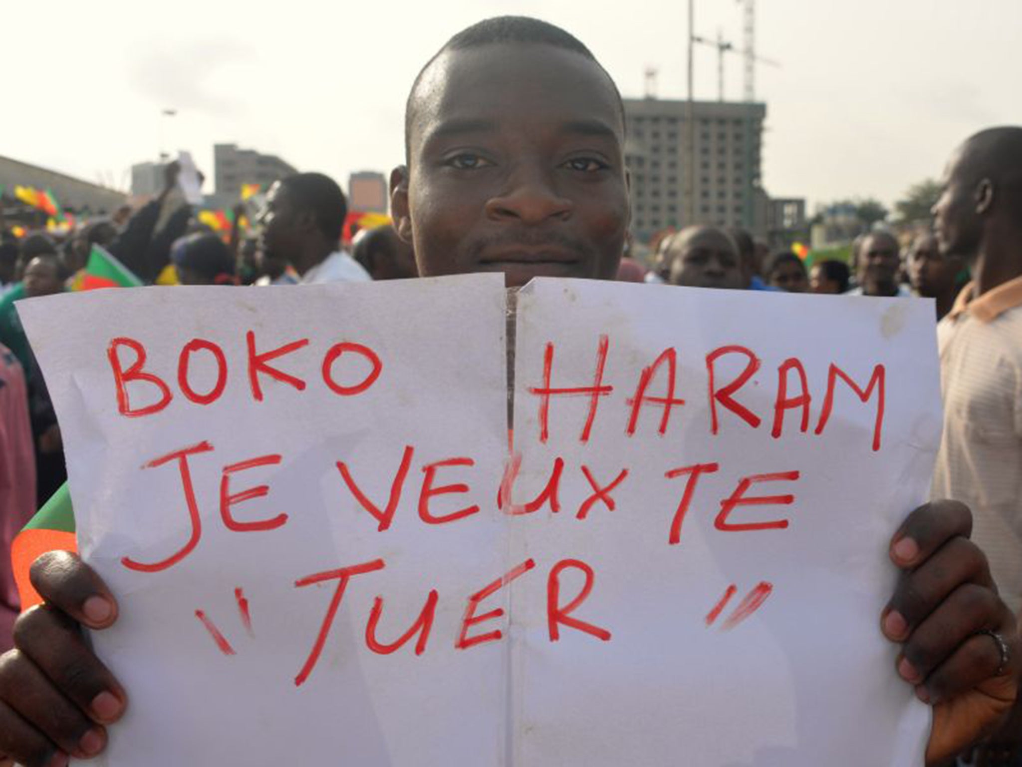 A man holds a placard that reads "Boko Haram, I want to kill you", in support of the Cameroonian army