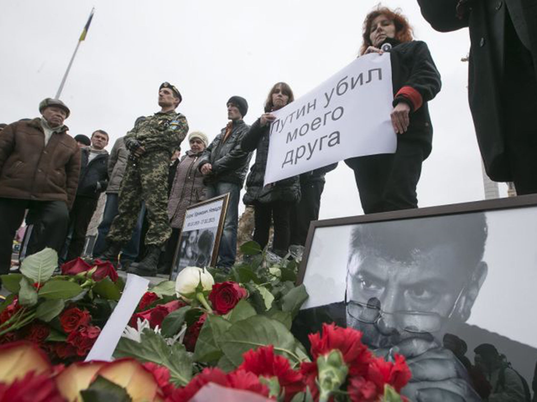 Ukrainian mourners hold a placard that reads 'Putin killed my friend' during a vigil in memory of Boris Nemtsov in Kiev