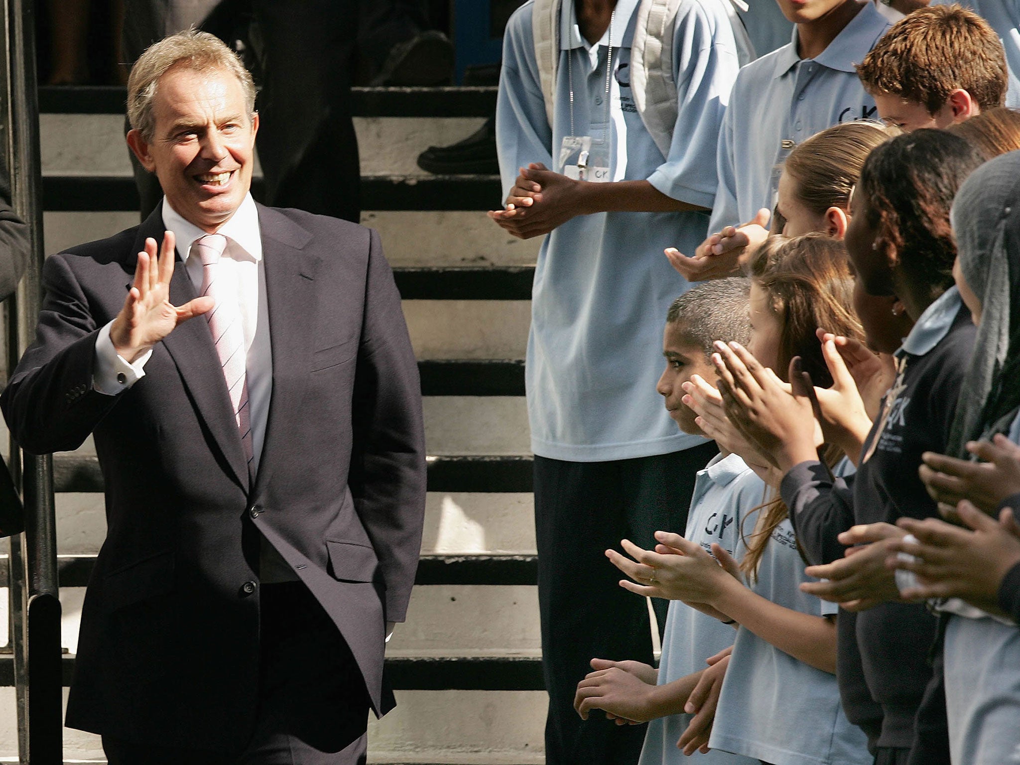 Tony Blair waves at students during his visit to Quintin Kynaston School on September 7, 2006, when he announced his resignation