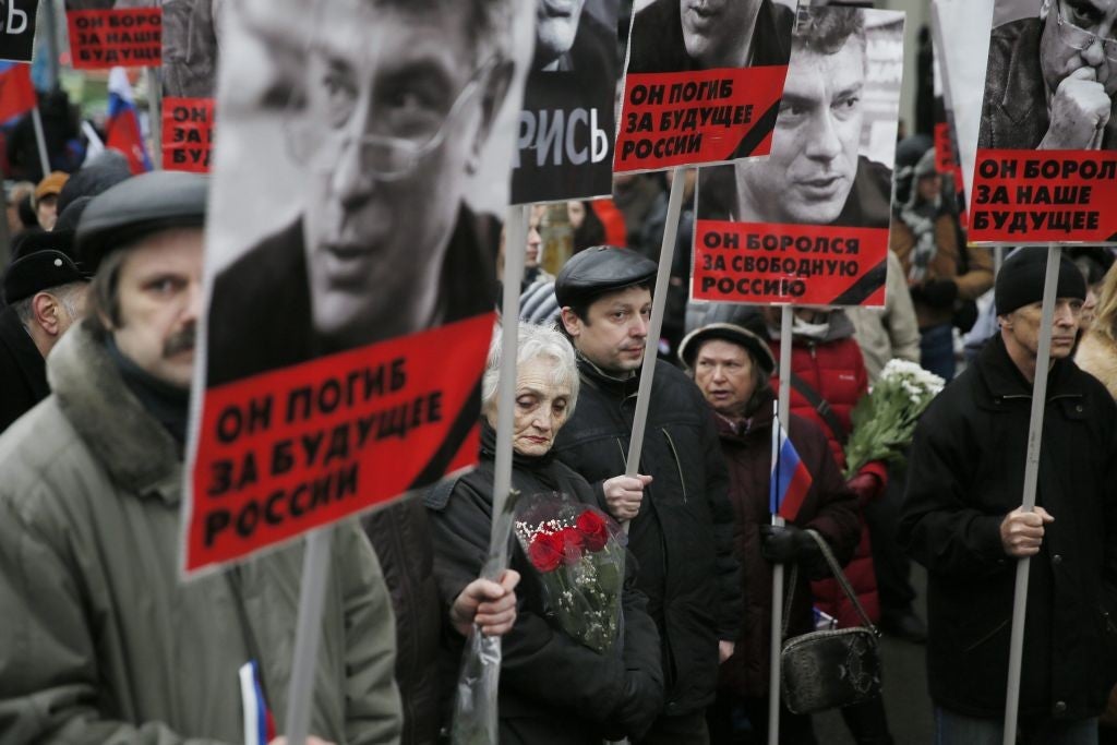 Marchers hold portraits of Boris Nemtsov during memorial march on Sunday morning