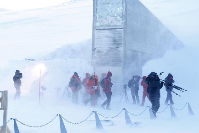  Journalists and cameramen walk near the entrance of the Svalbard Global Seed Vault