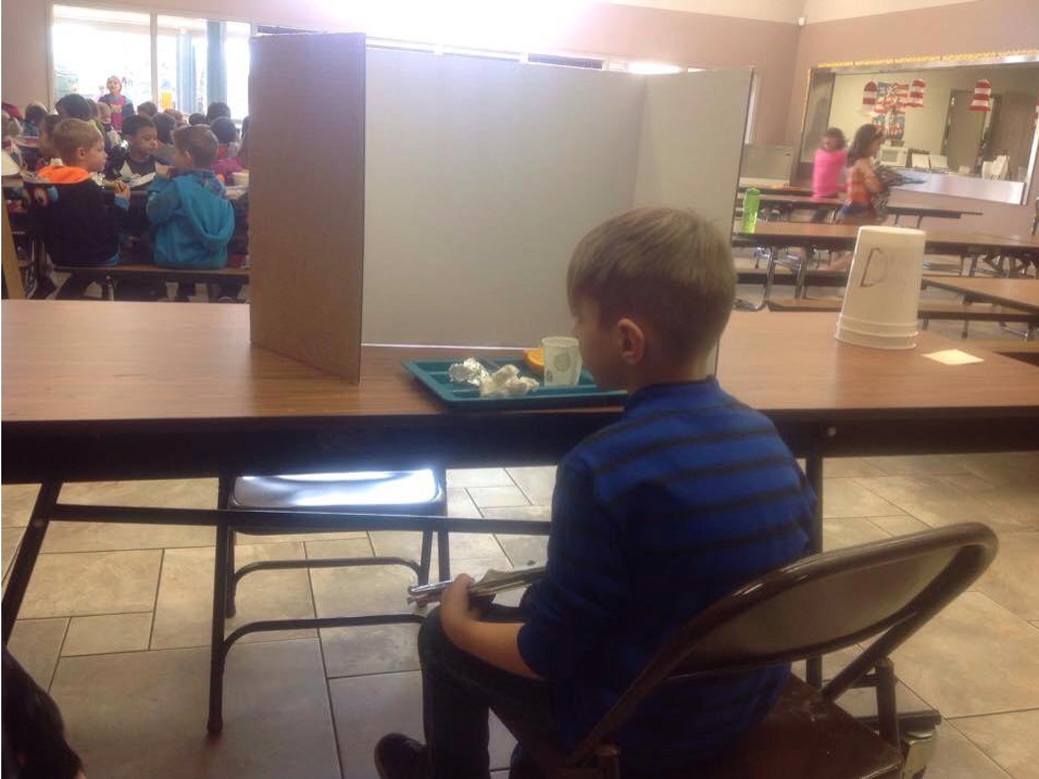 Image posted to Facebook by Hunter Cmelo's grandmother shows the six-year-old being made to eat behind a screen