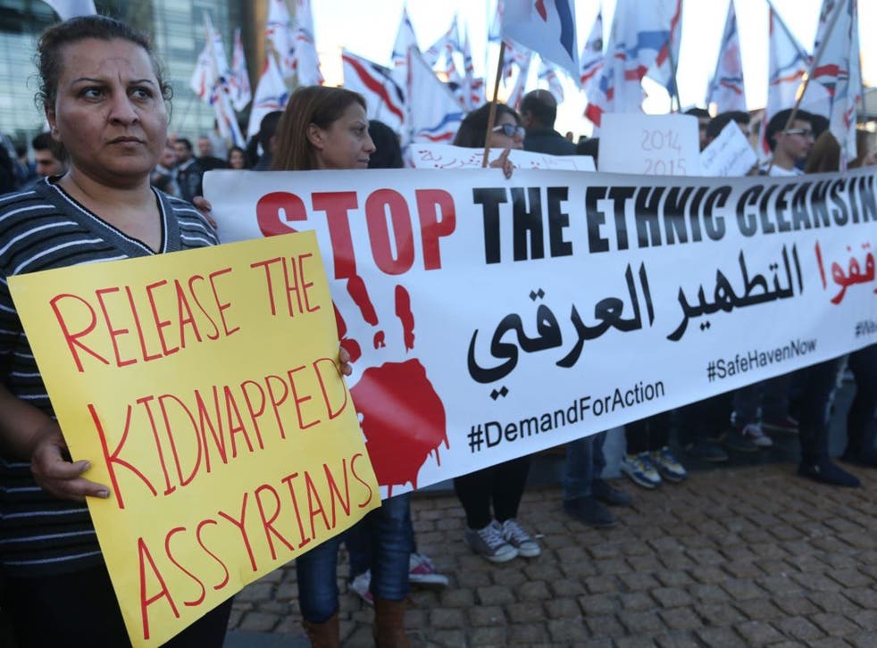 Assyrians hold placards and wave their community's flag as they protest with several hundred people in solidarity with Christians abducted in Syria and Iraq, in downtown Beirut, Lebanon Saturday, Feb. 28, 2015.
