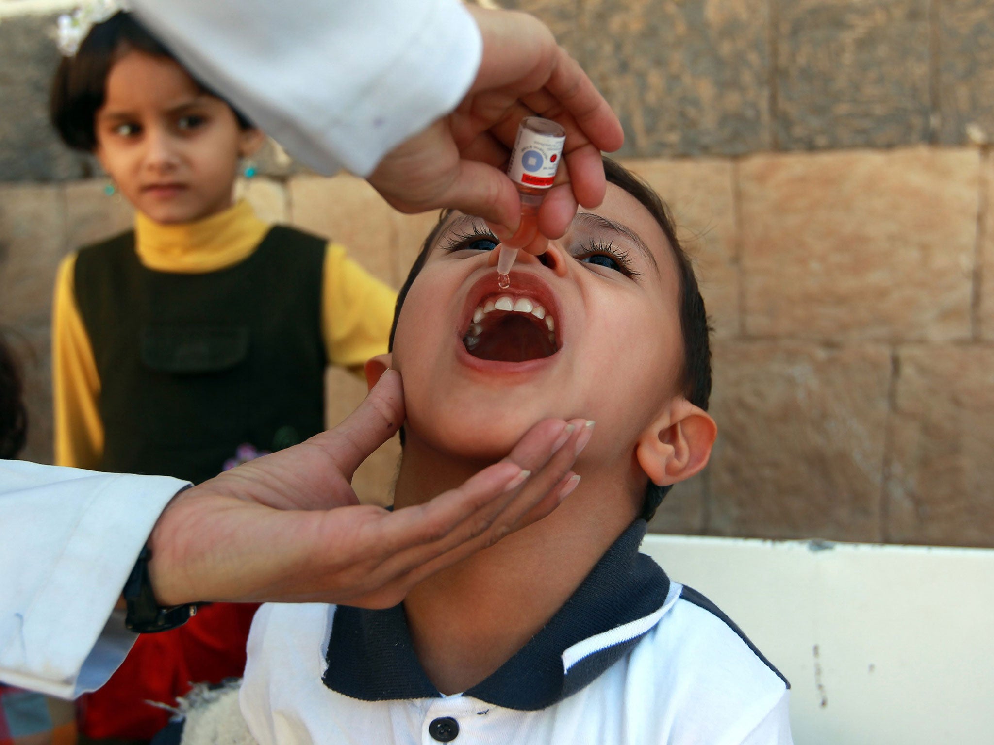 A doctor administers a polio vaccine to a child 