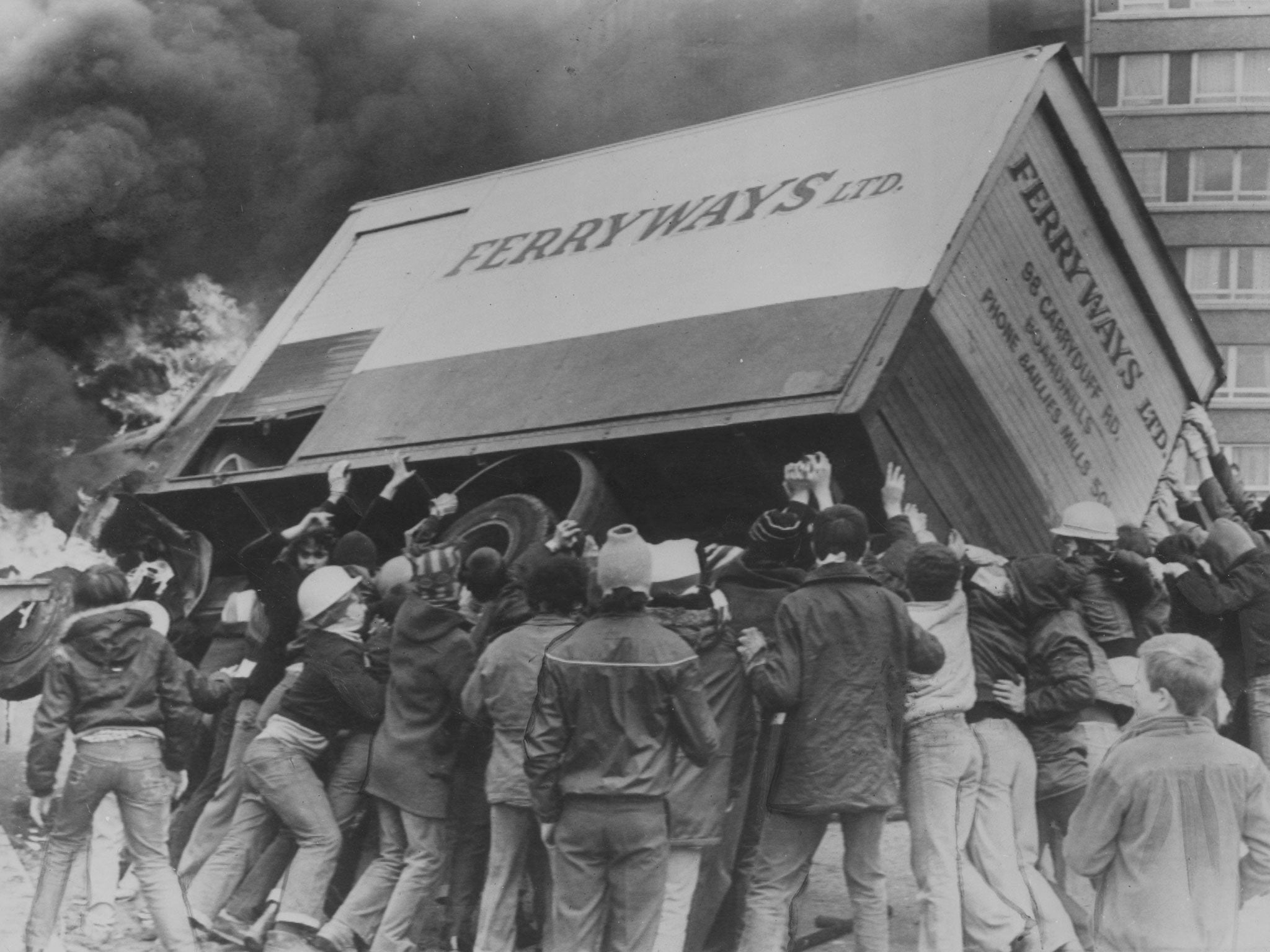 Rioters turn a burning lorry into a barricade in the Divis Flats area of Belfast during The Troubles