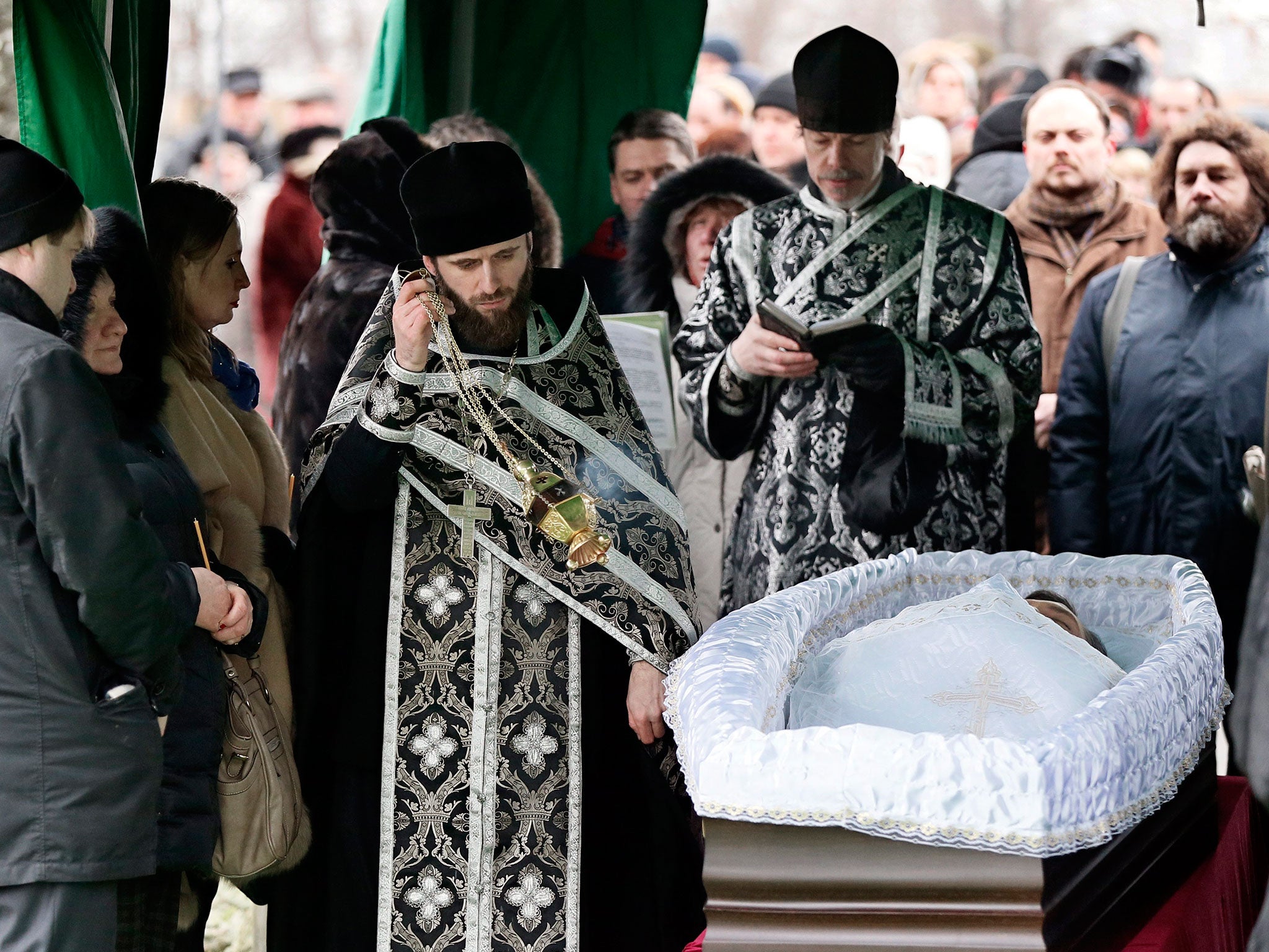 An Orthodox priests blesses the coffin