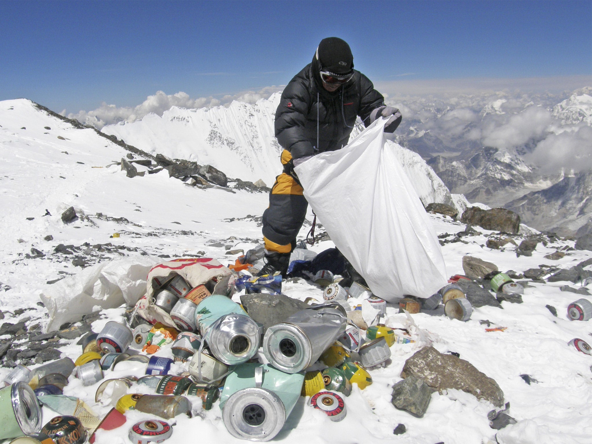 A Nepalese sherpa collects garbage, left by climbers, during an Everest clean-up expedition at Mount Everest in 2010