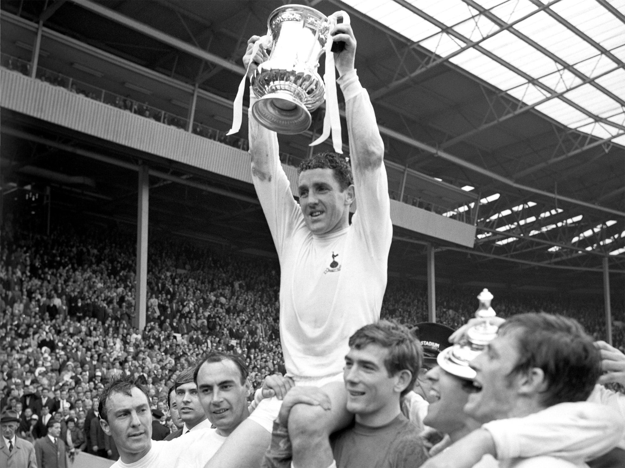 Dave Mackay holds the FA Cup trophy aloft following Tottenham Hotspur's victory in 1967